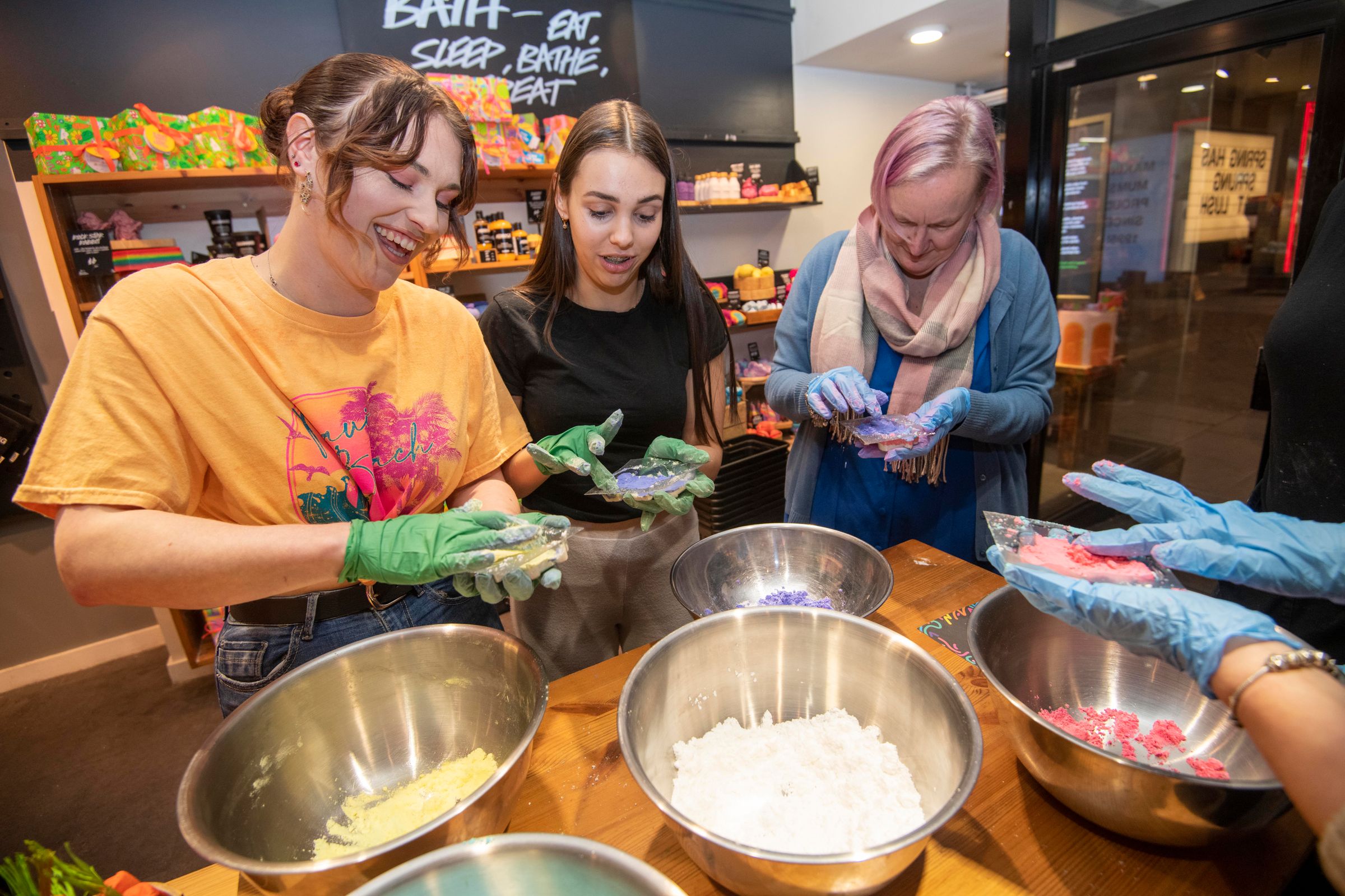 Three women making bathbombs at a Lush workshop