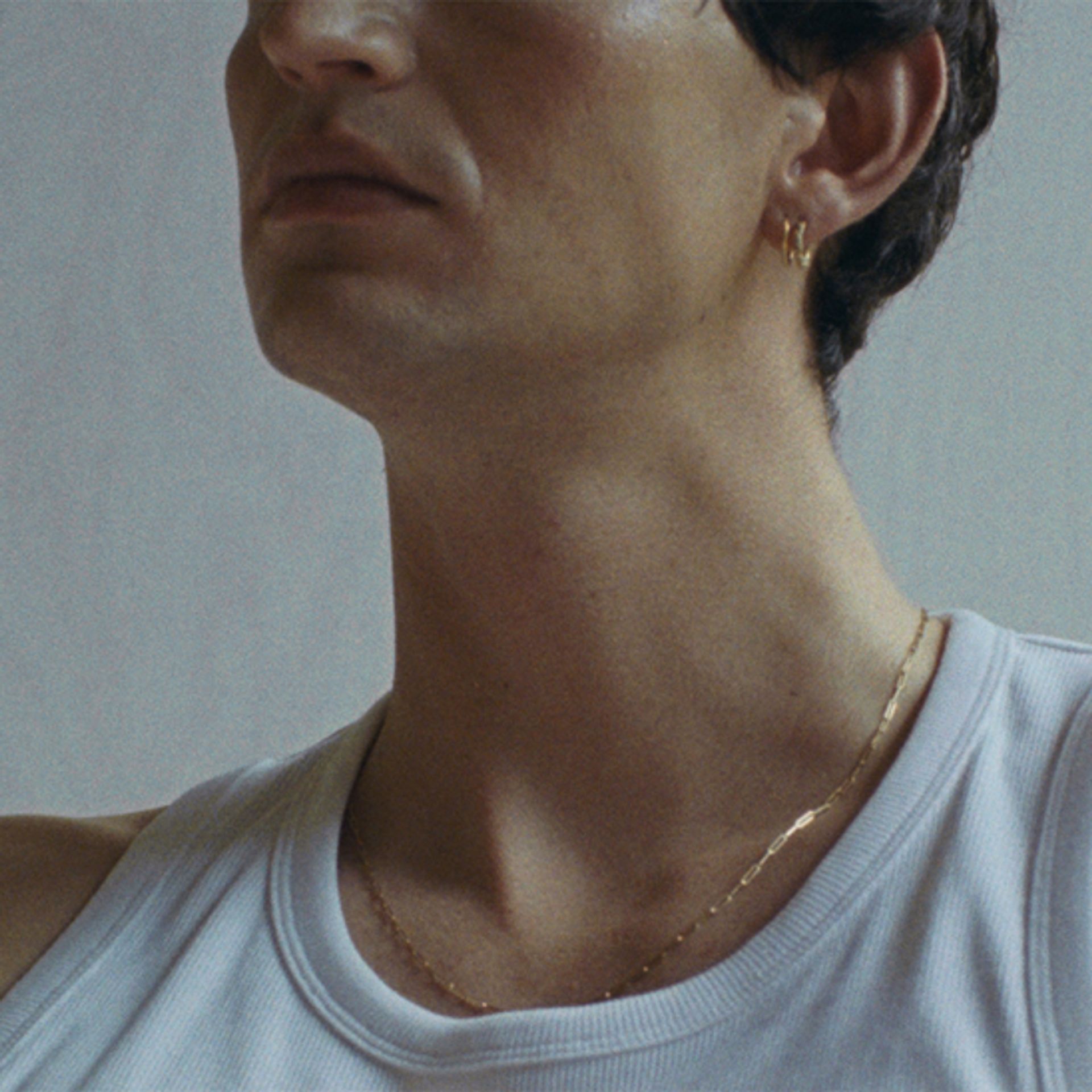 Close-up of a man's jaw and neck with smooth, firm skin in soft light — anti-aging skincare for men by Apollon Studios