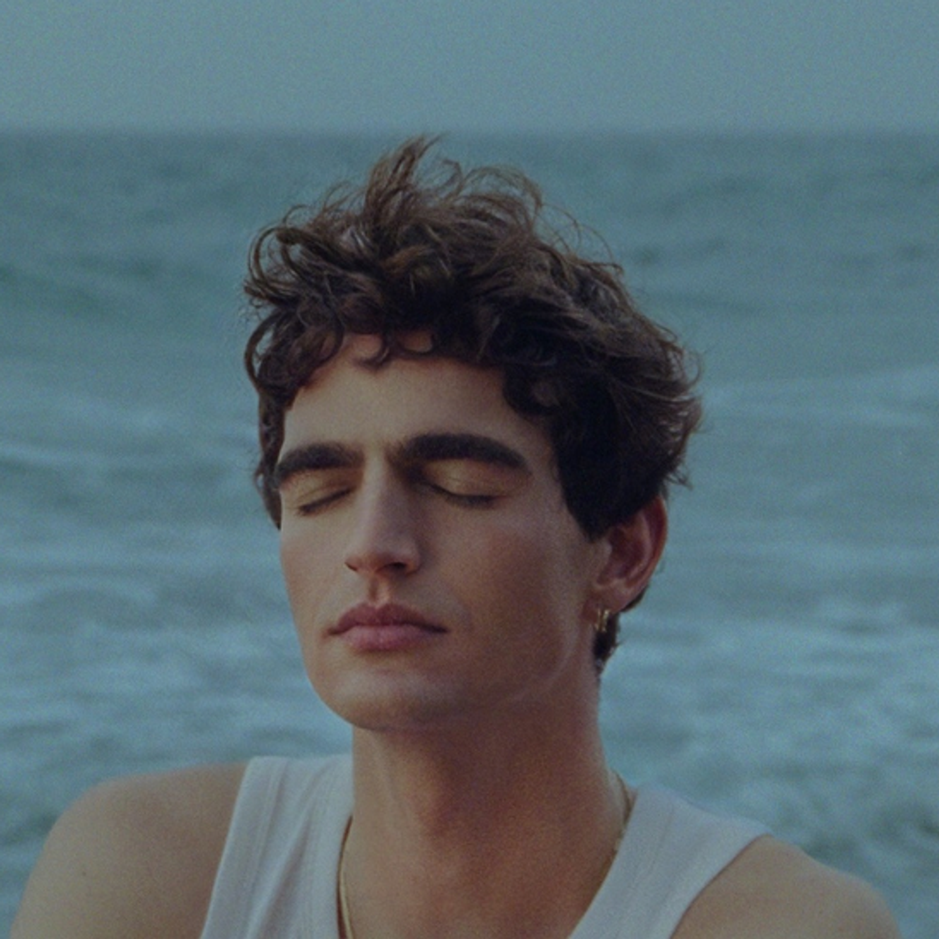 Young man with eyes closed in natural sunlight — editorial image for Apollon Studios article "By Available Light"