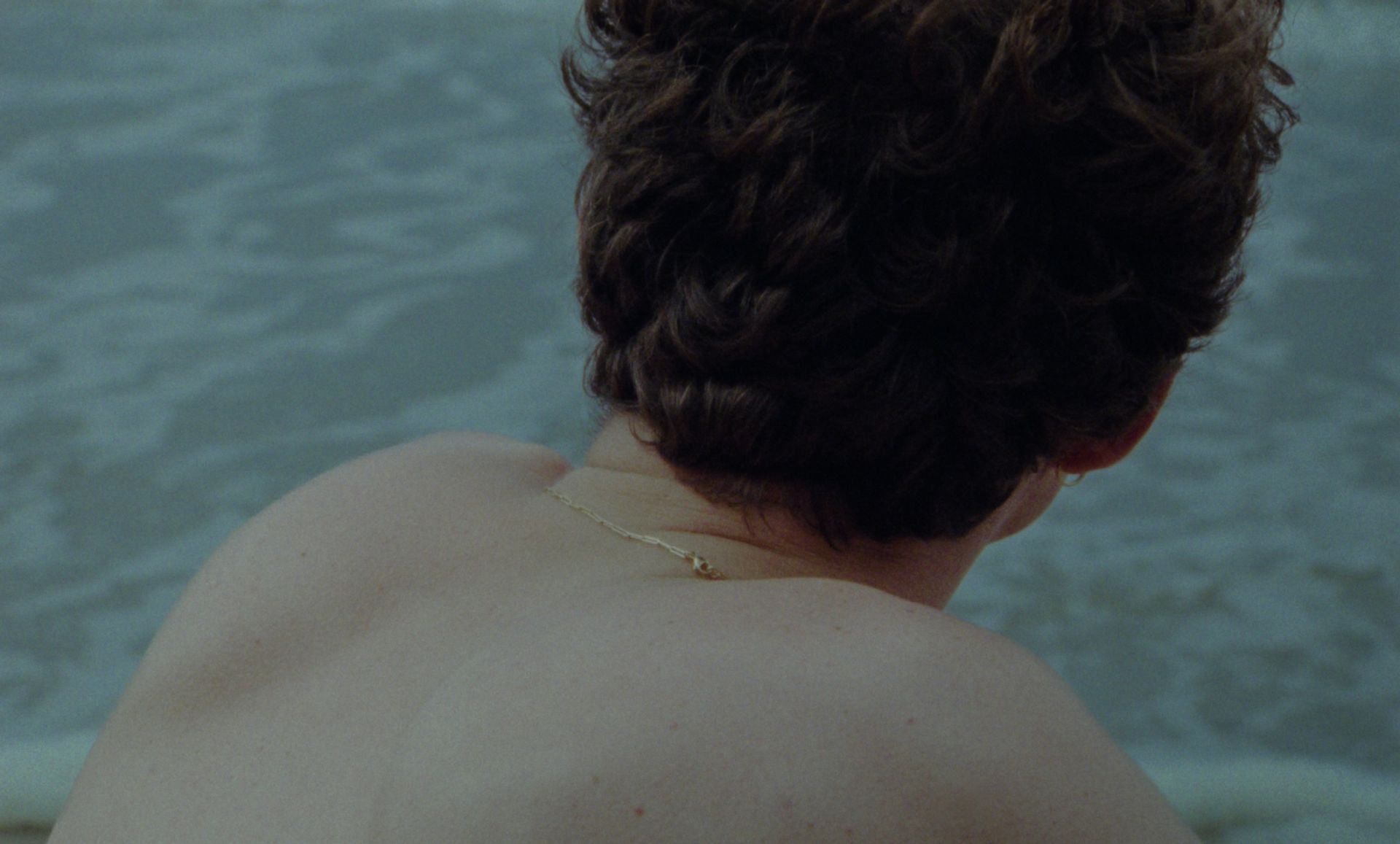 A serene, dreamlike sequence of a man looking out over the ocean, reflecting the pure and calming essence of Apollon Studios."