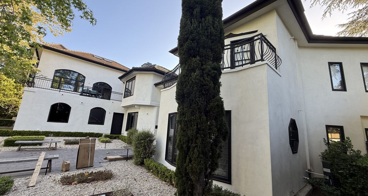 Completed re-stucco, Spanish two-story with cypress