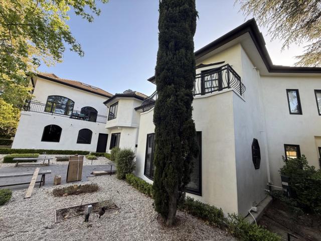 Completed re-stucco, Spanish two-story with cypress