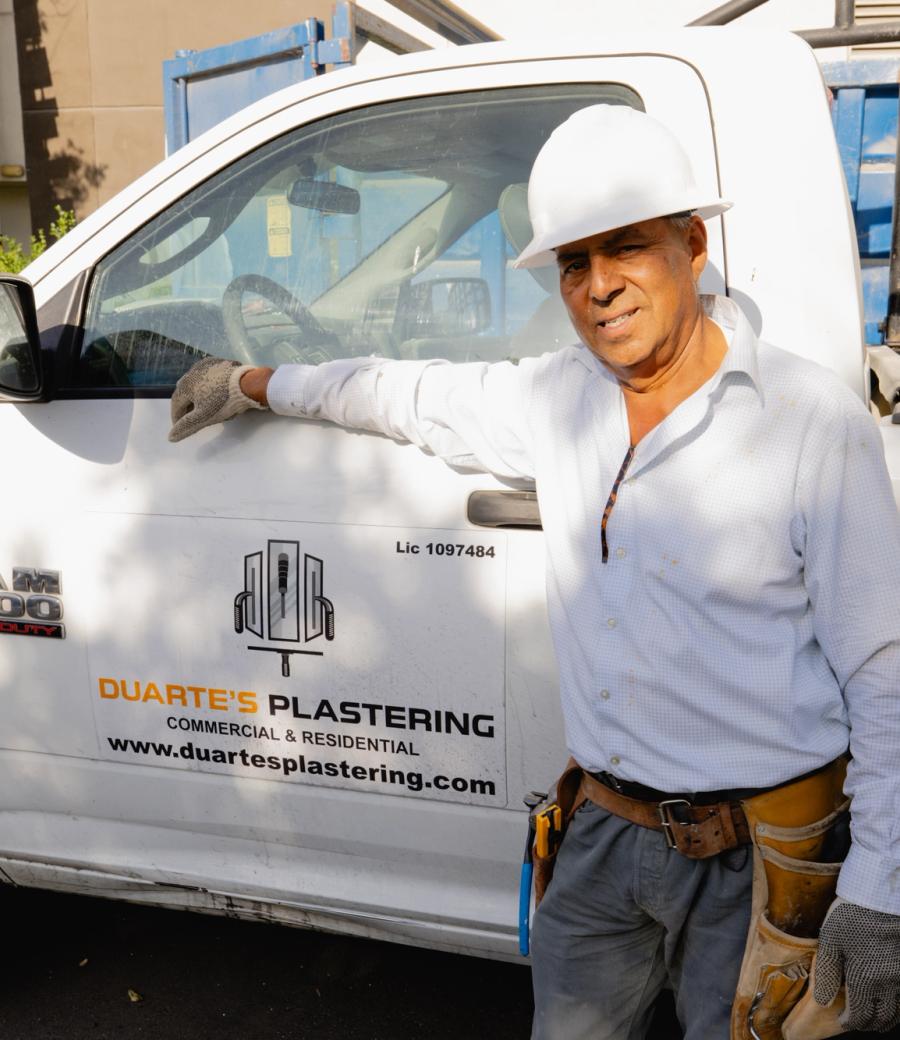 Omar Duarte, owner of Duarte’s Plastering, beside his branded work truck