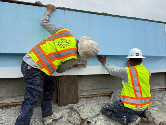 Crew setting a foam parapet cap — Duarte's Plastering project near Fullerton, CA