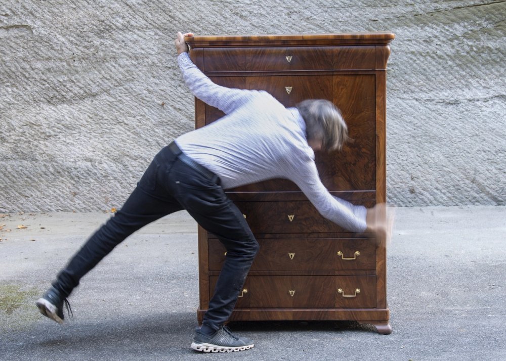 Bild von Andres Huber mit einem restaurierten Möbel.