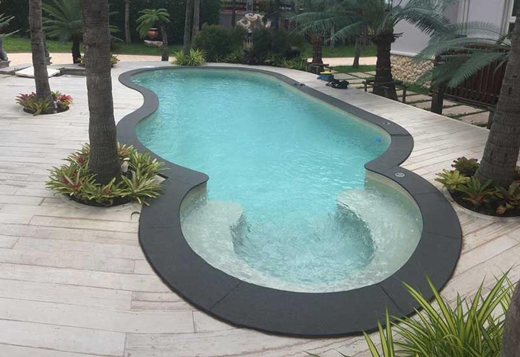 สระว่ายน้ำทรงอิสระปูผิวด้วย PVC LINER สีฟ้าใส พร้อมลานไม้และสวนสไตล์ทรอปิคอล โดย J.D.Pools