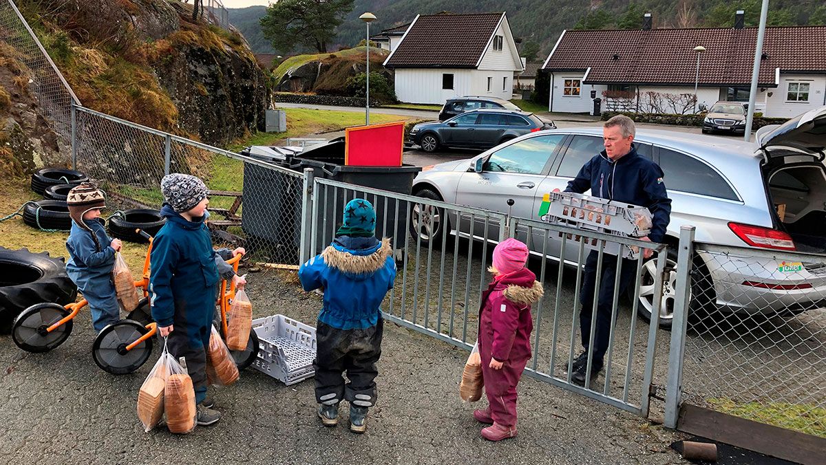 Mann ved en port og barnehagebarn