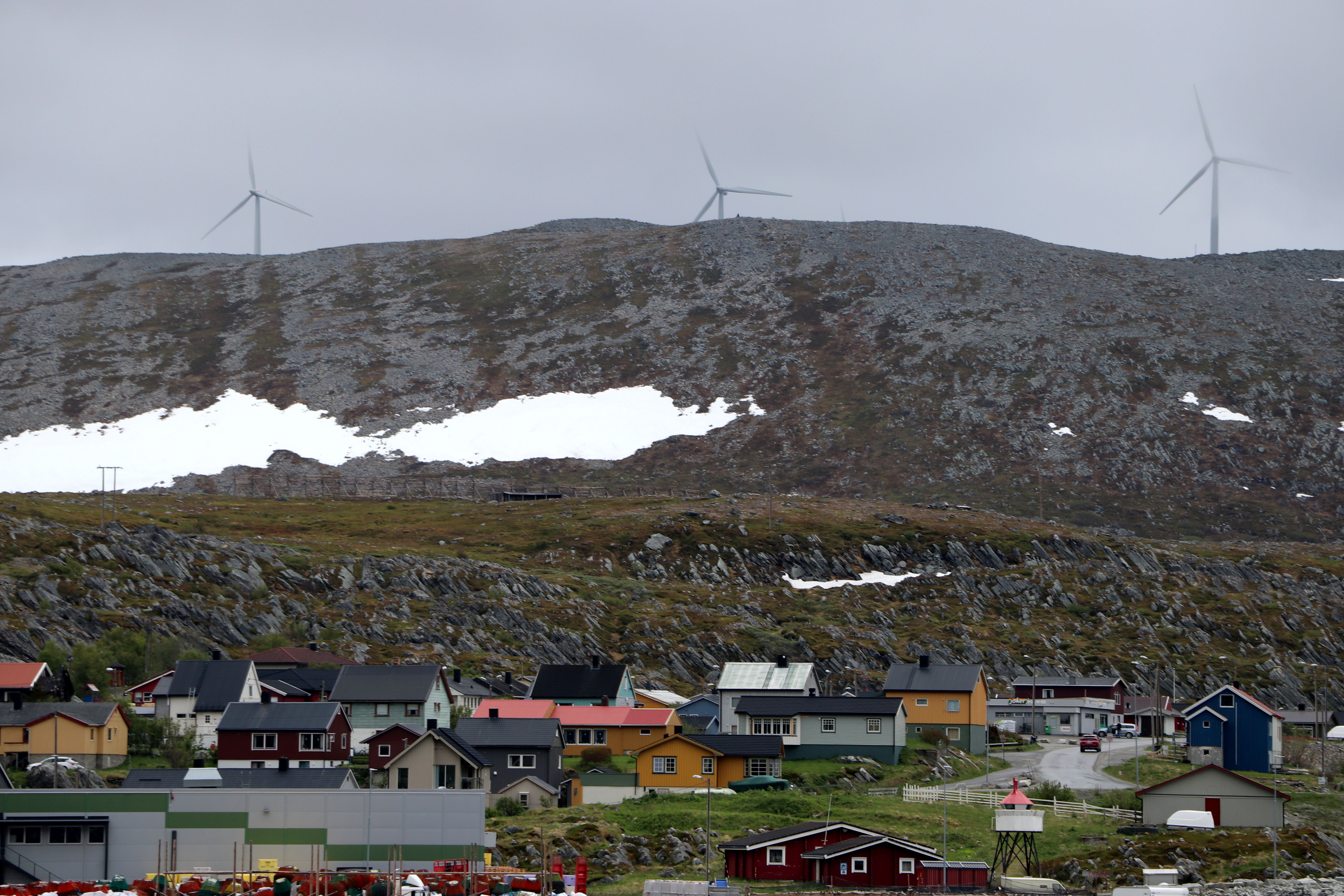Bilde av bolighus, fjell og vindmøller