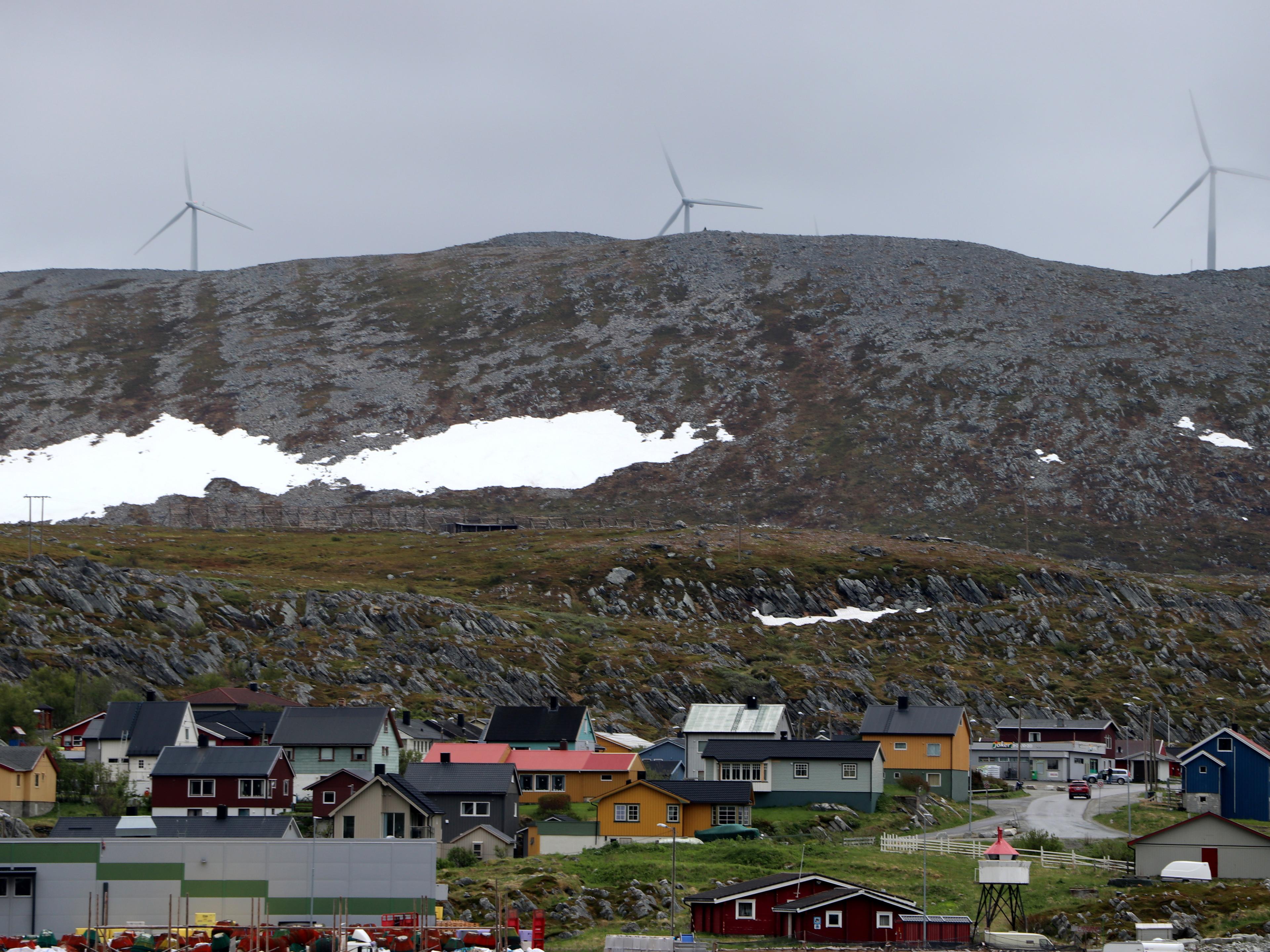 Bilde av bolighus, fjell og vindmøller