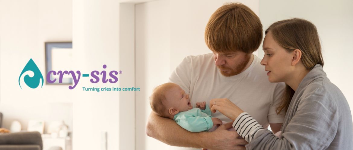 A dad holding a crying baby with the mum leaning in to soothe the baby. With the words cry-sis, turning cries into comfort written at the side.