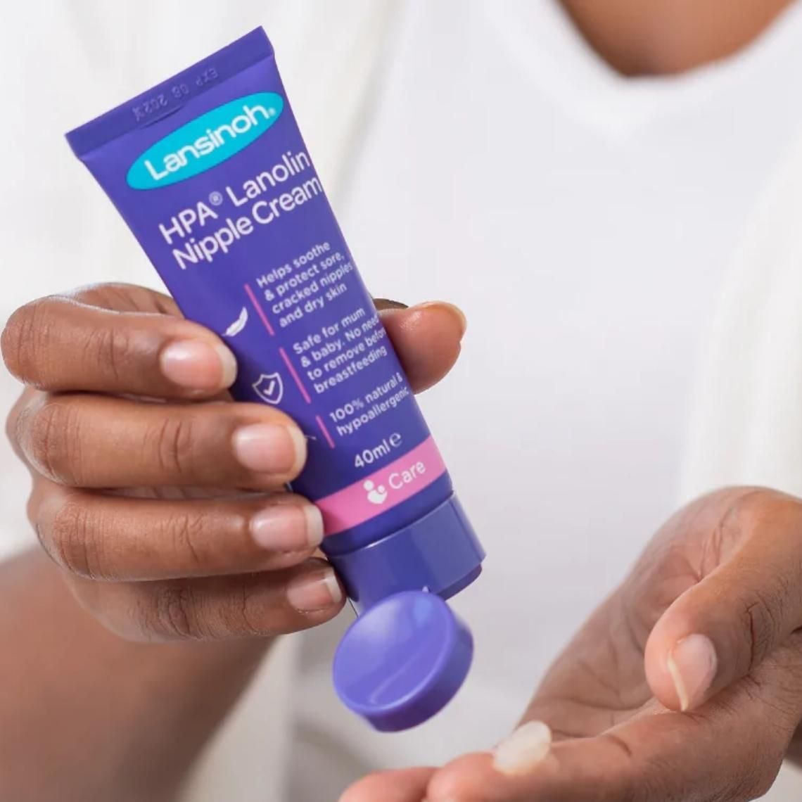 A woman applying a small amount of Lansinoh nipple cream to her finger