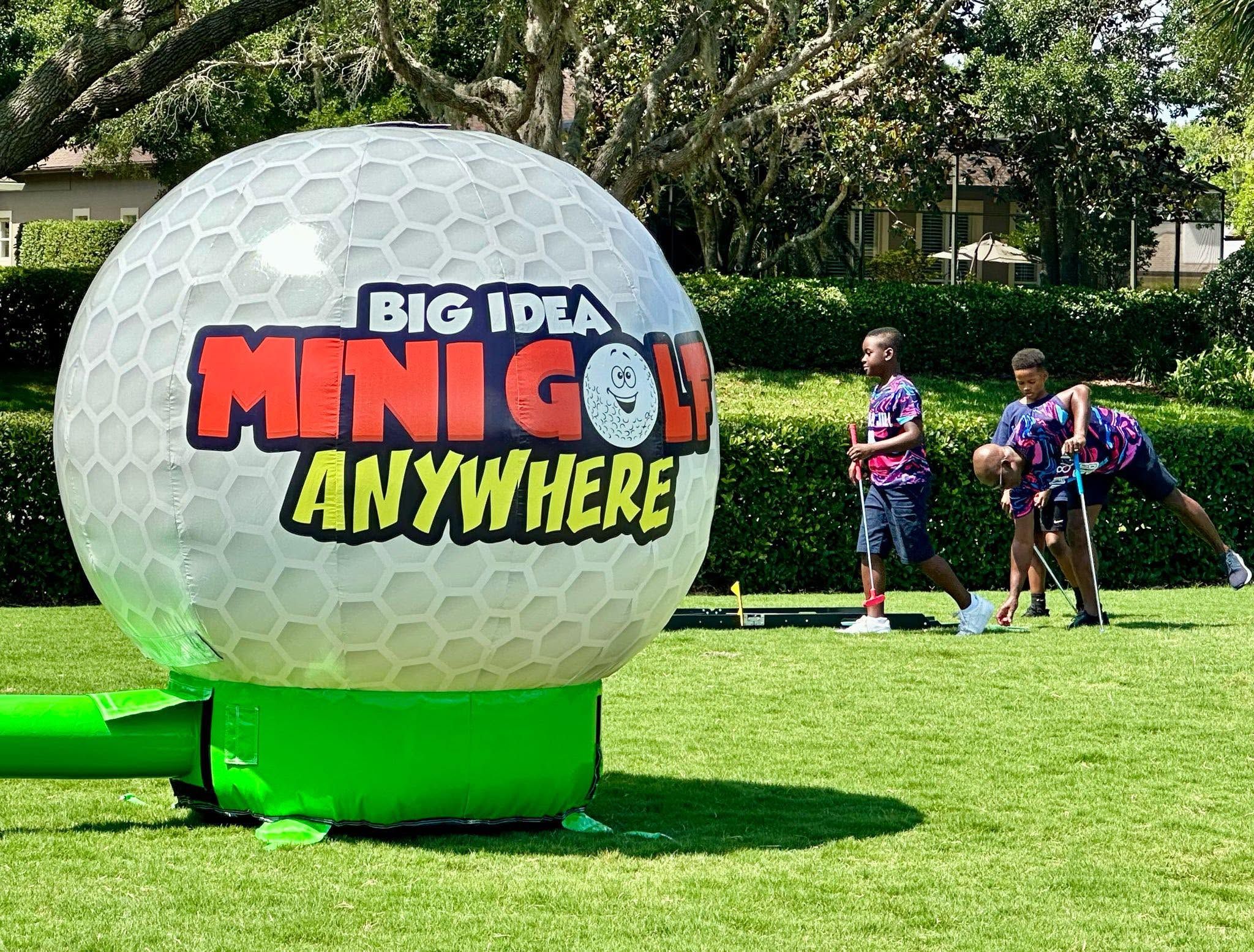 a giant inflatable Big Idea Mini Golf Anywhere ball on a lawn