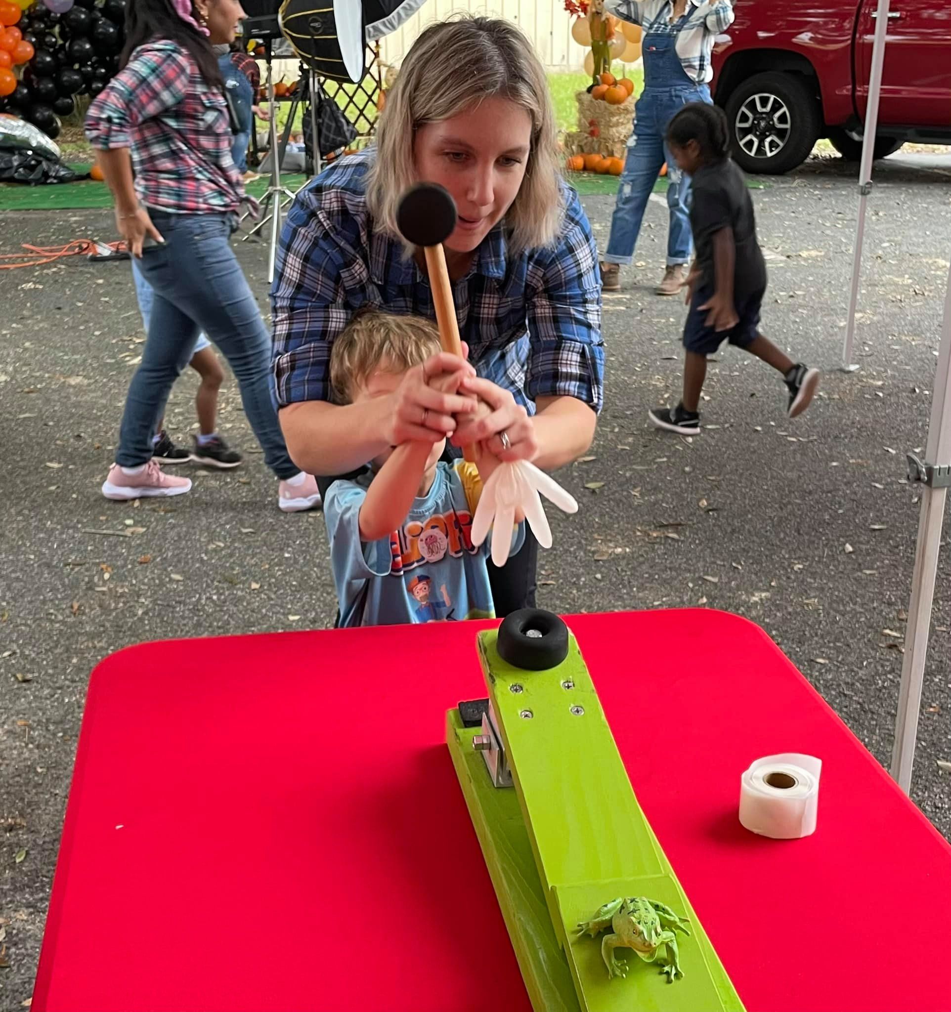 kid and parent playing frog flinger at a carnival themed birthday party