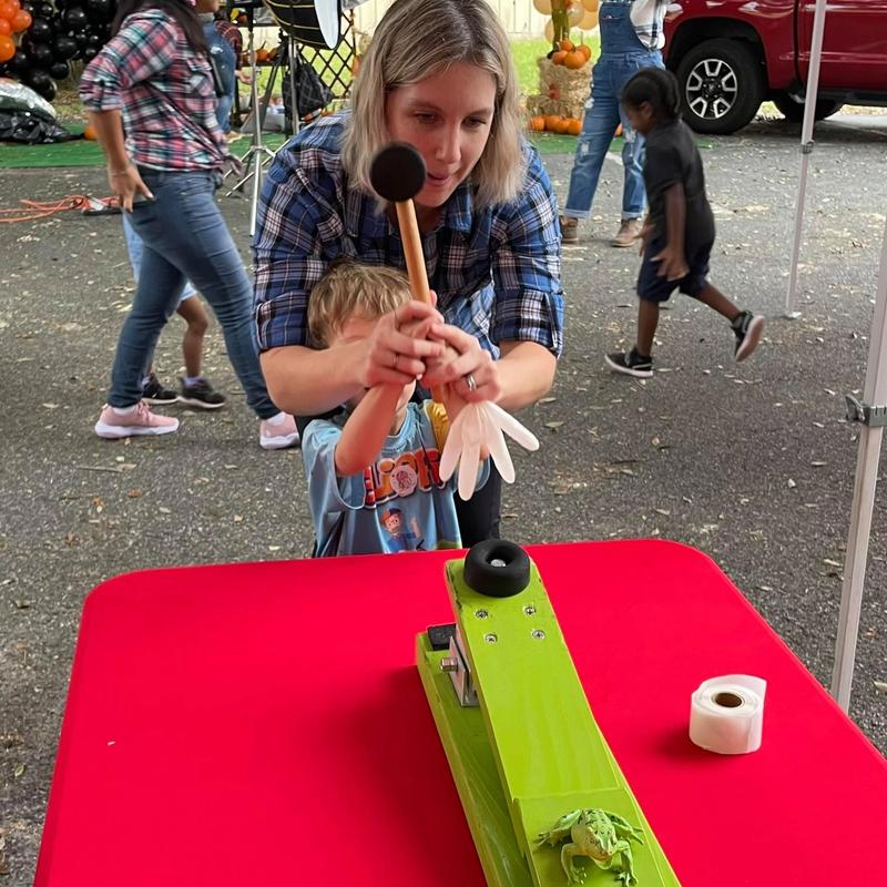 kid and parent playing frog flinger at a carnival themed birthday party