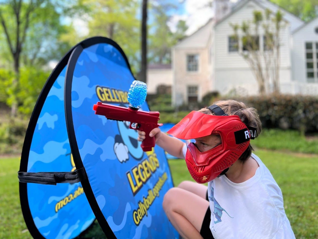 A boy in a red mask takes aim around a pop-up bunker