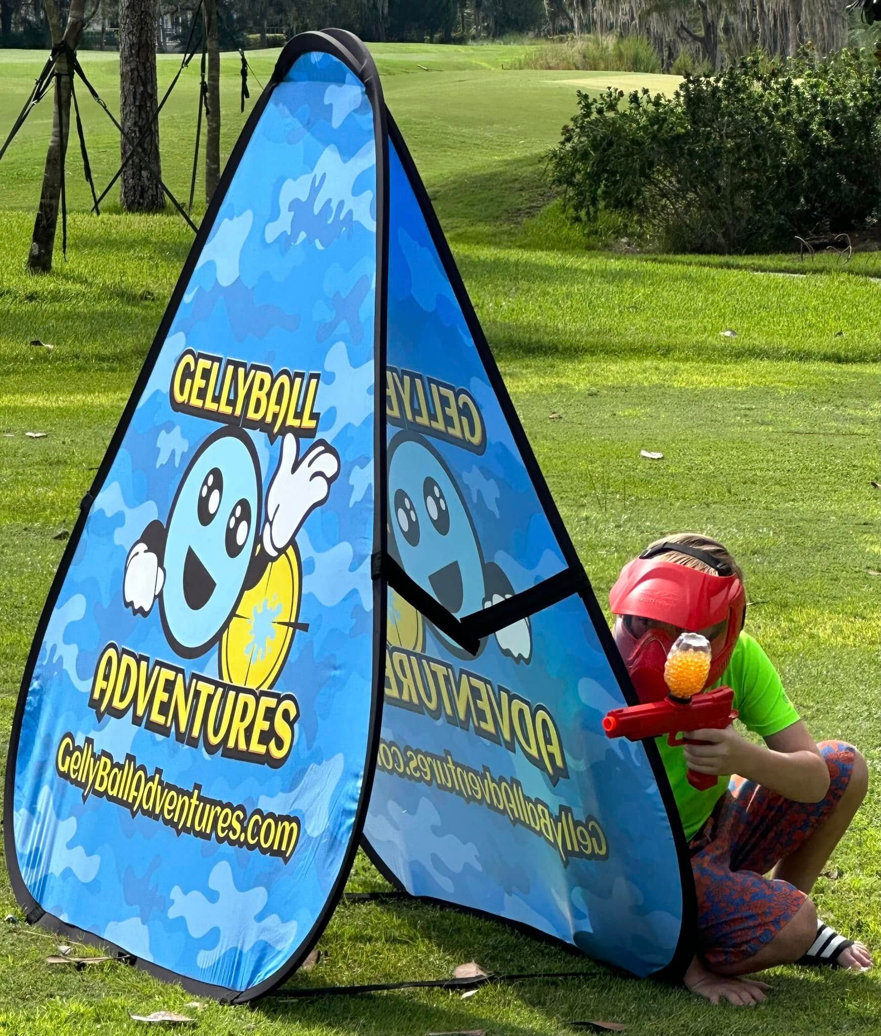 A child in a red mask crouches behind a pop-up bunker