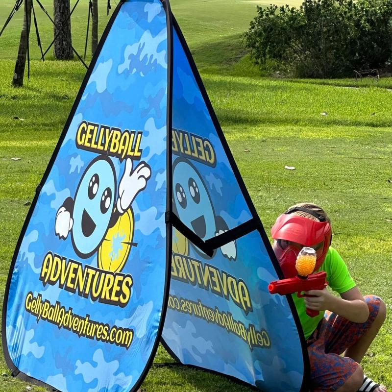 A child in a red mask crouches behind a pop-up bunker
