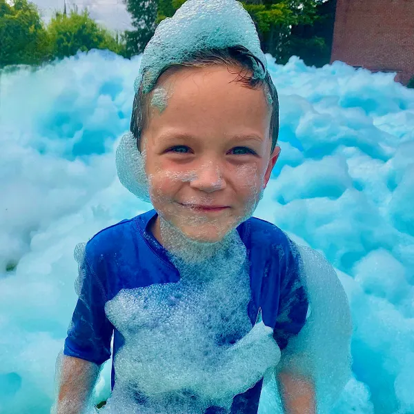 A kid covered in blue foam at a foam birthday party in Orlando