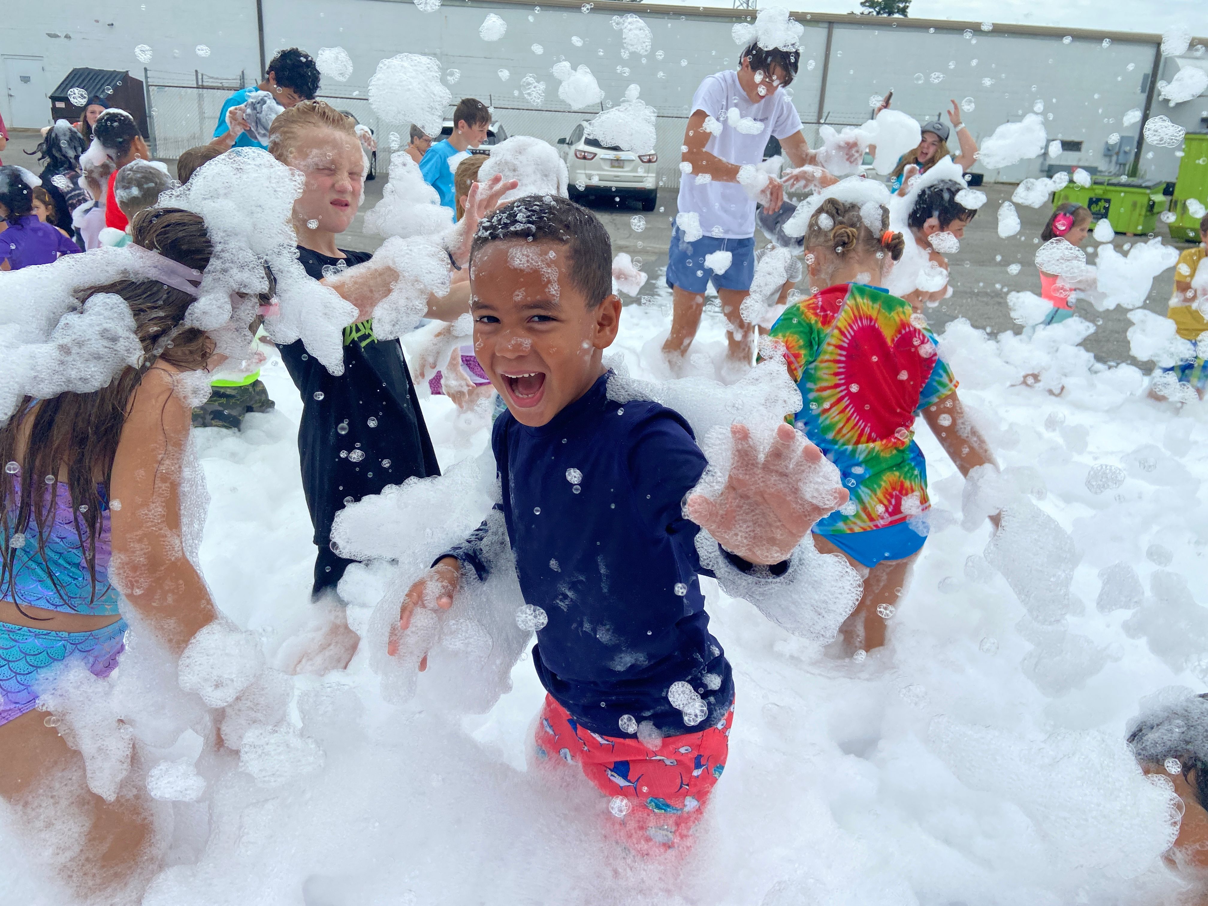Children laughing while running through foam at a birthday party in Atlanta
