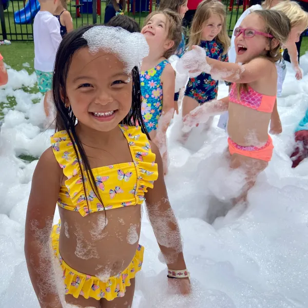 You kids smiling and running through foam at a birthday party in Tampa Bay