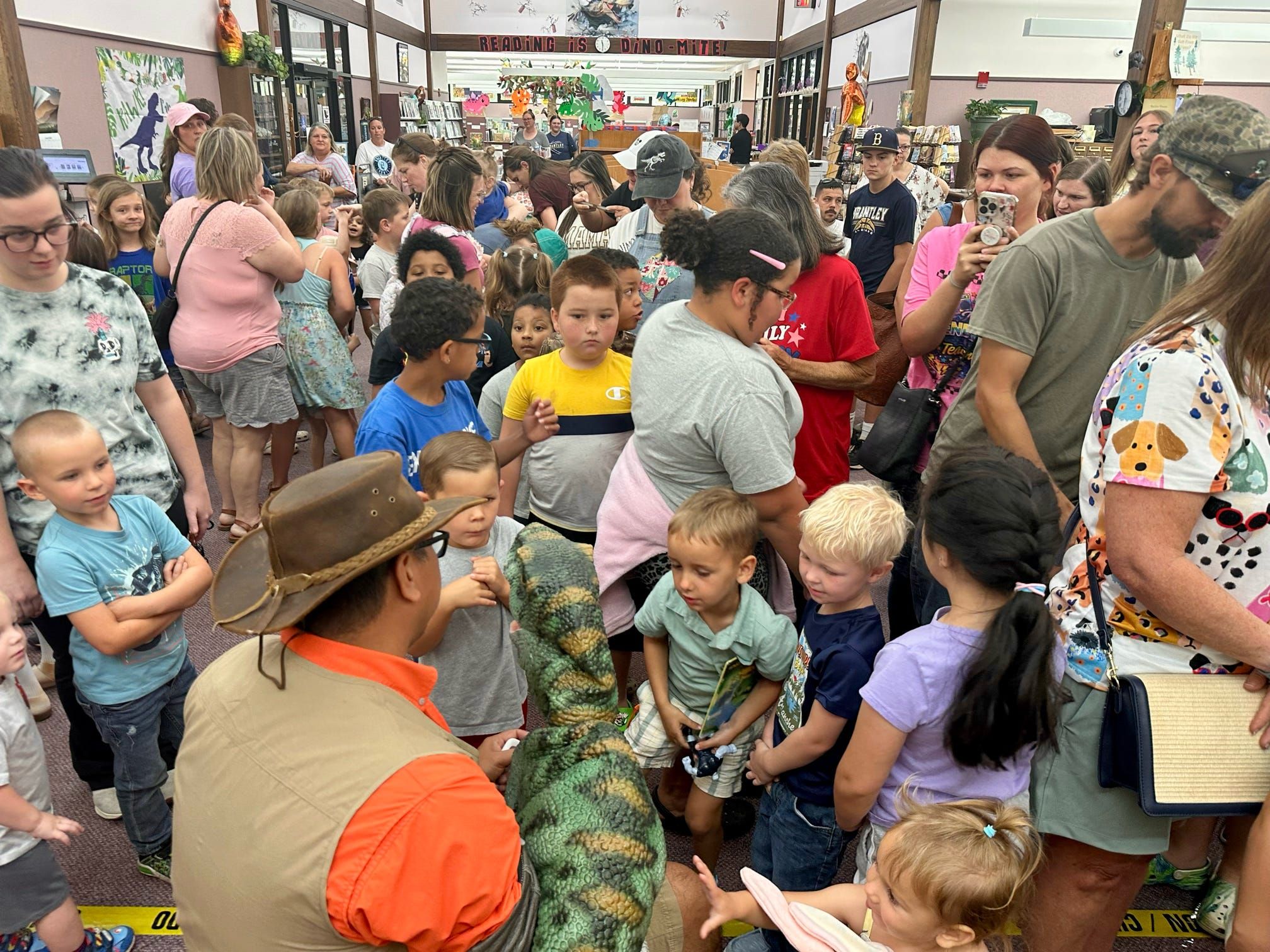 A packed room of families meets a trainer and a lifelike baby T. rex