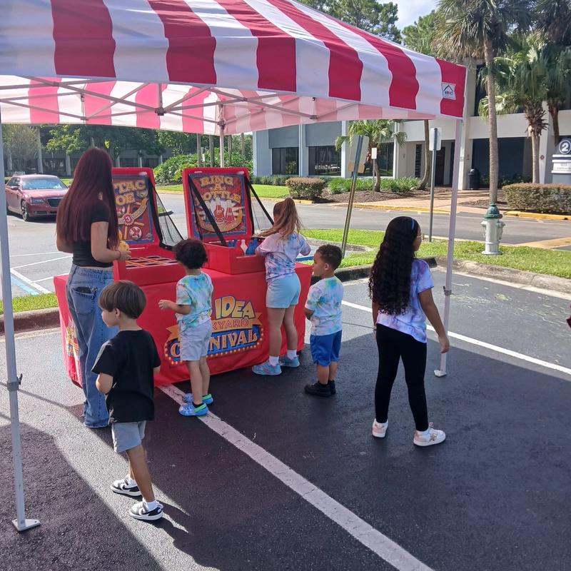 red and white striped carnival tent and classic games setup at a birthday party