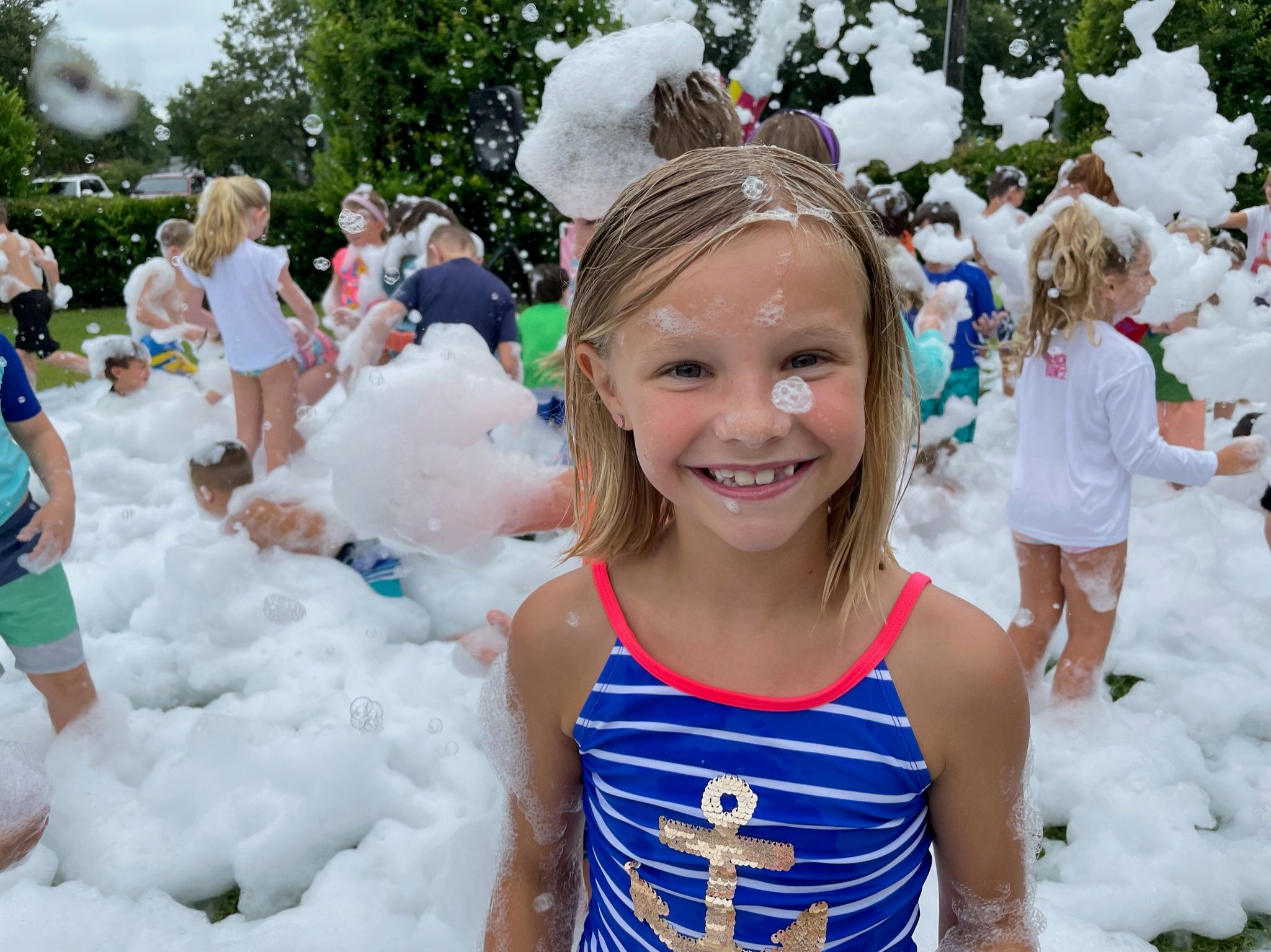 A girl at a foam party birthday in Jacksonville Florida smiling