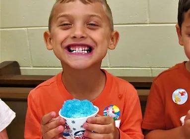 Kids enjoying snow cones at a carnival event