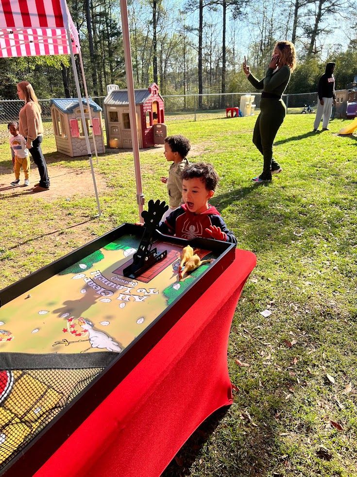 happy kid playing chicken flight school carnival game