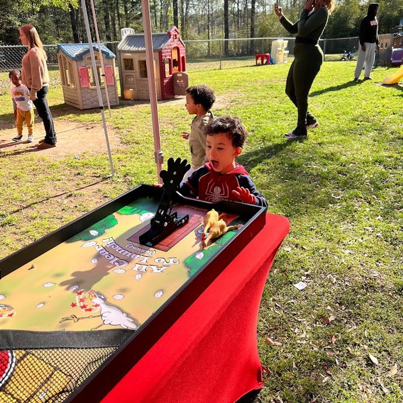 happy kid playing chicken flight school carnival game