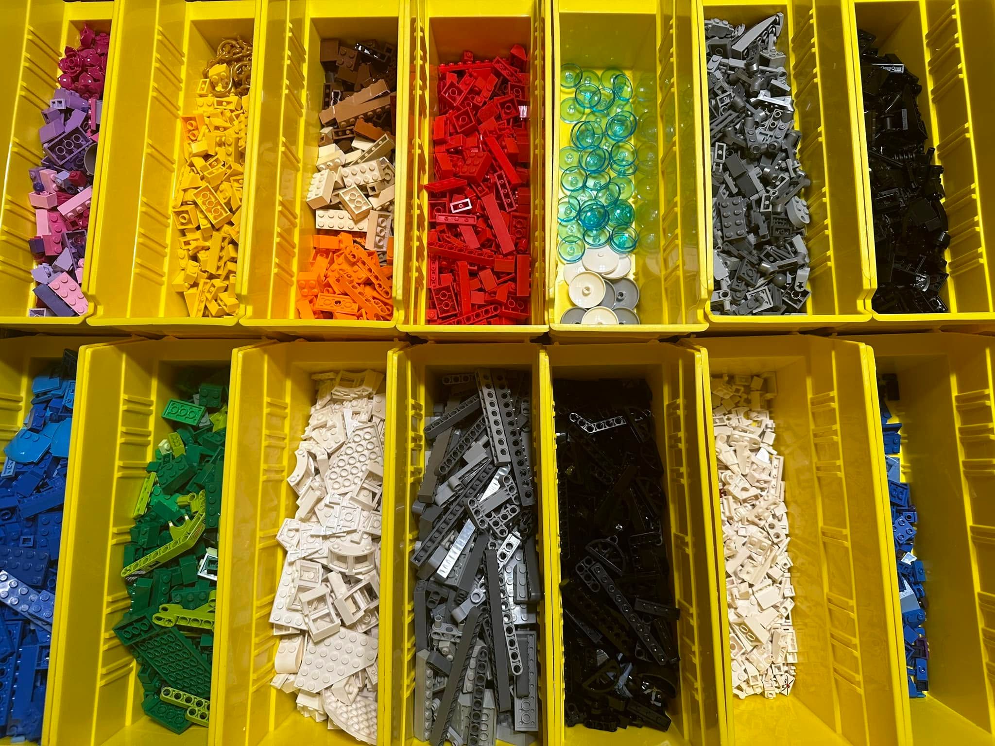 Rows of yellow bins with building bricks sorted by color
