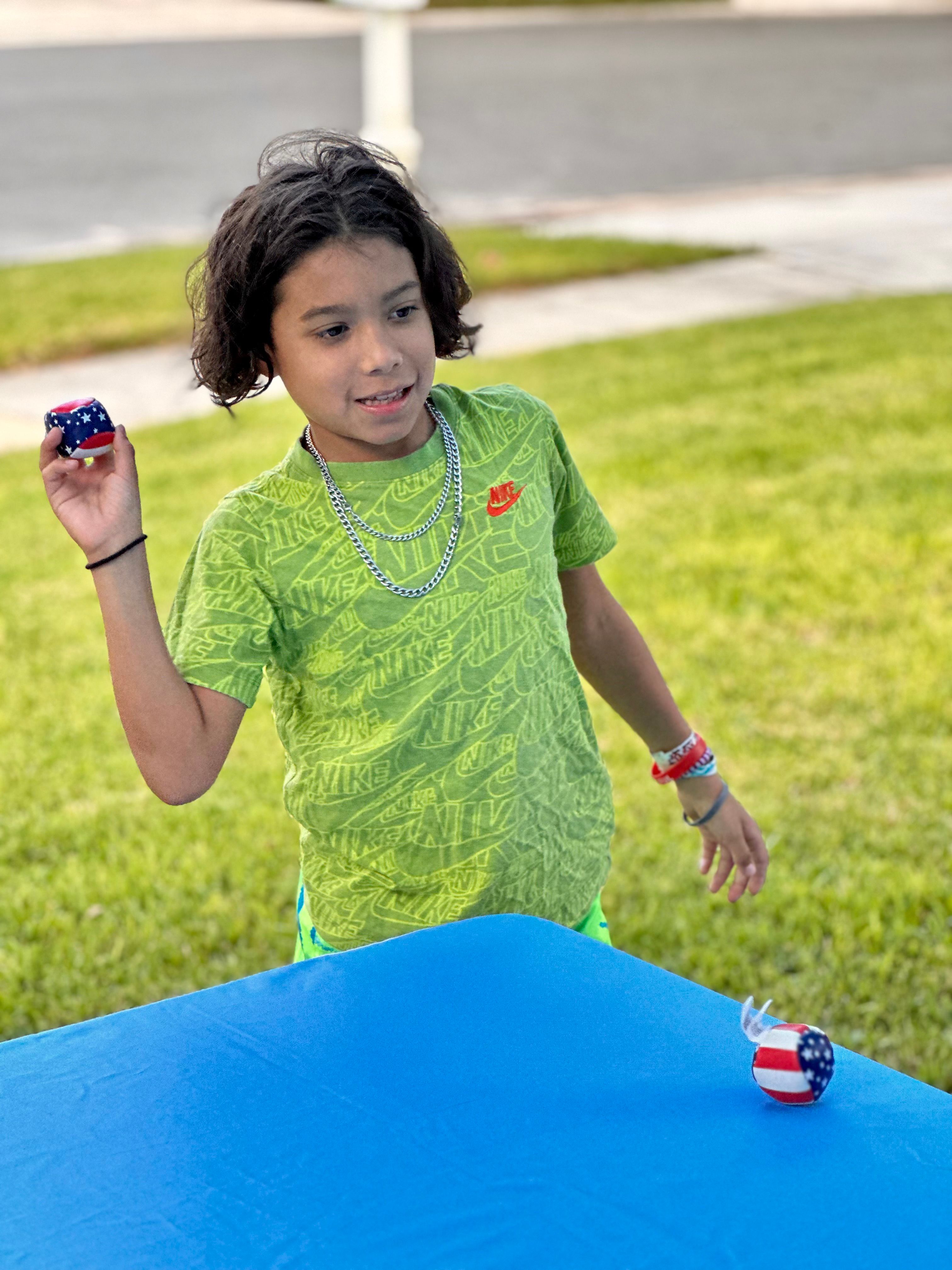A boy tosses a beanbag at a winter table game