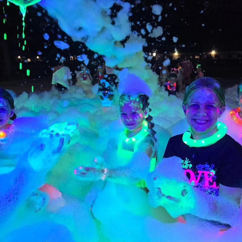 kids at a glow in the dark foam party