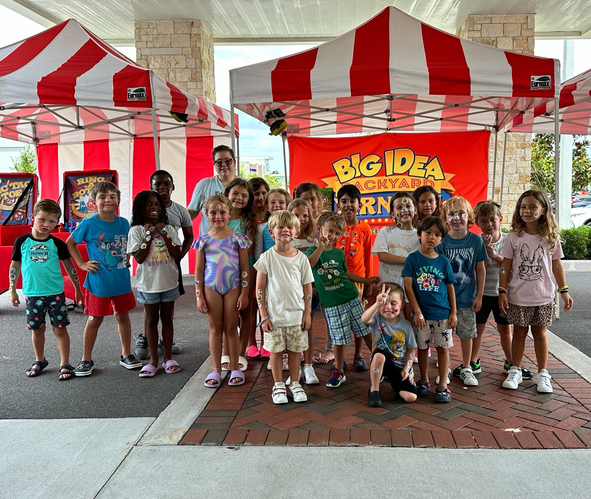 kids standing in front of carnival games and red and white striped tents at a daycare in Orlando.