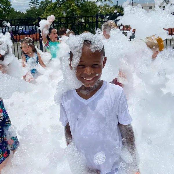 Kid smiling covered in foam at a foam birthday party