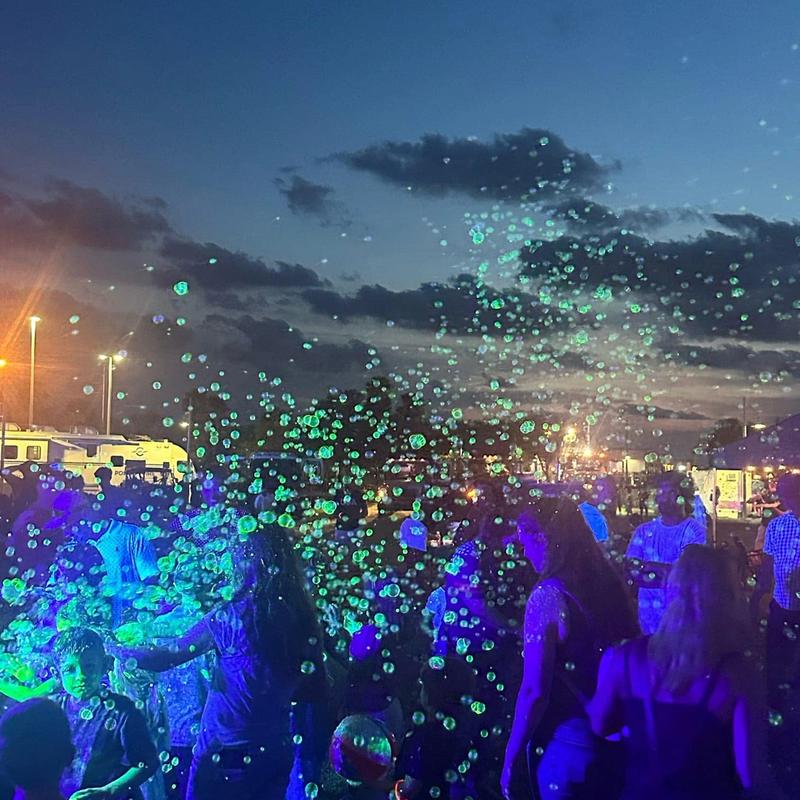 a night crowd under glowing bubbles at a community event