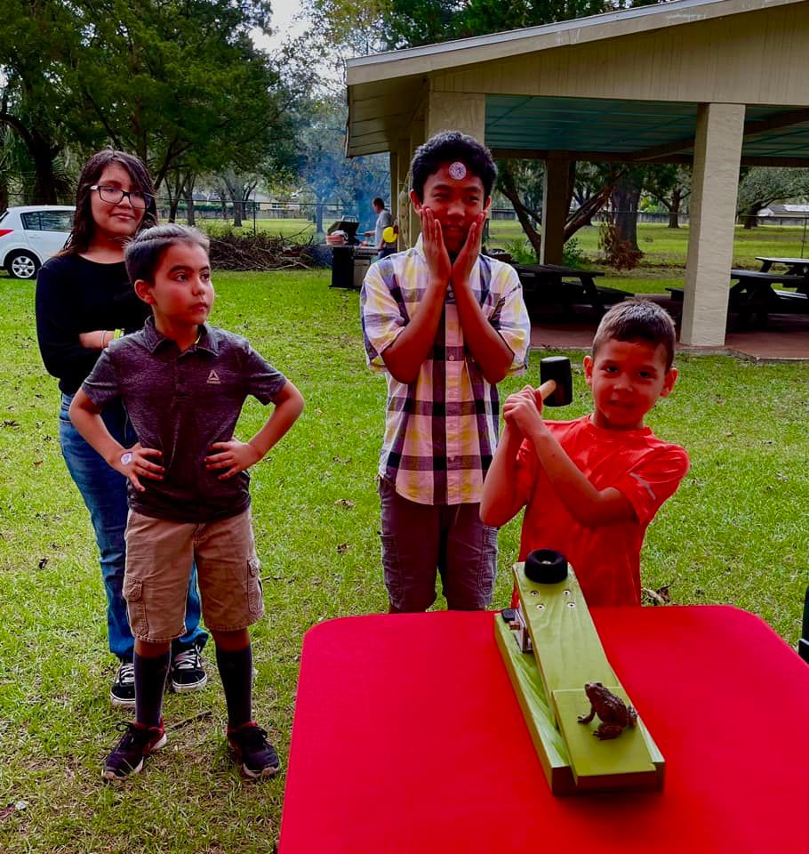kids playing frog flinger at a carnival