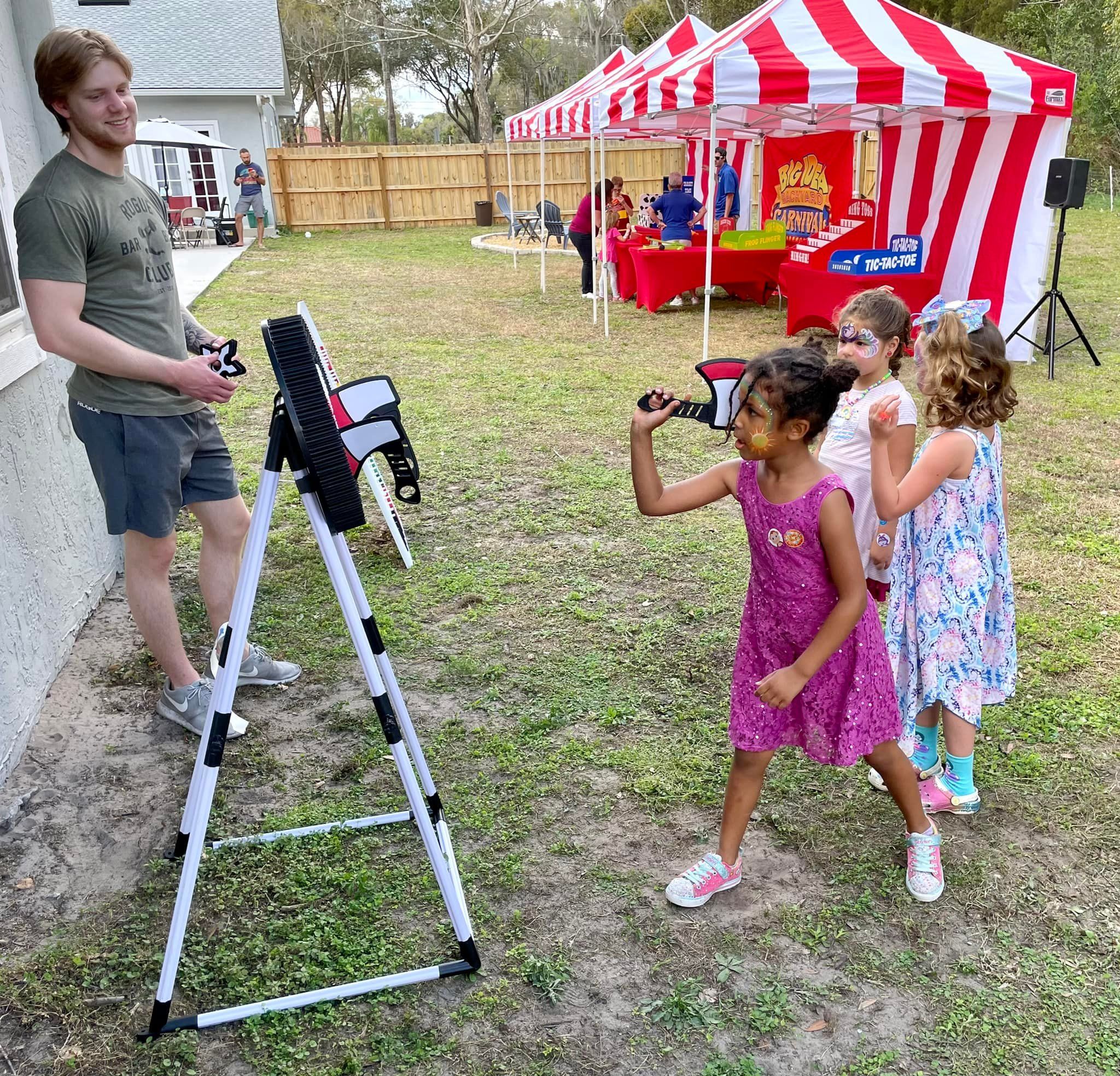 kids at a carnival themed birthday party playing axe throwing