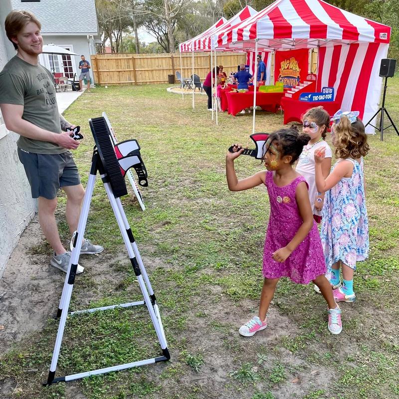 kids at a carnival themed birthday party playing axe throwing