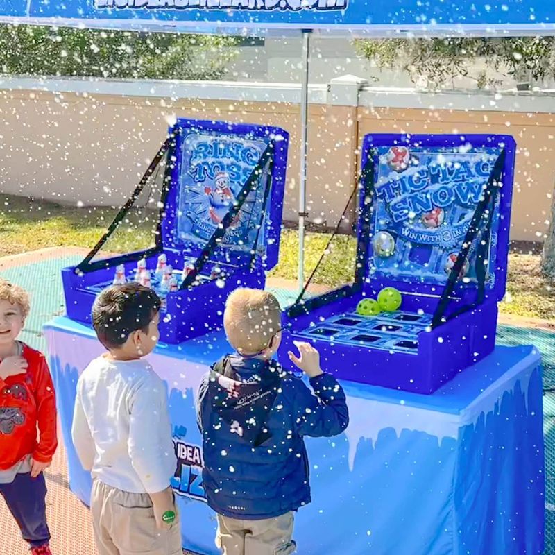 Three boys play Ring Toss and Tic Tac Snow under a Blizzard tent as snow falls around them