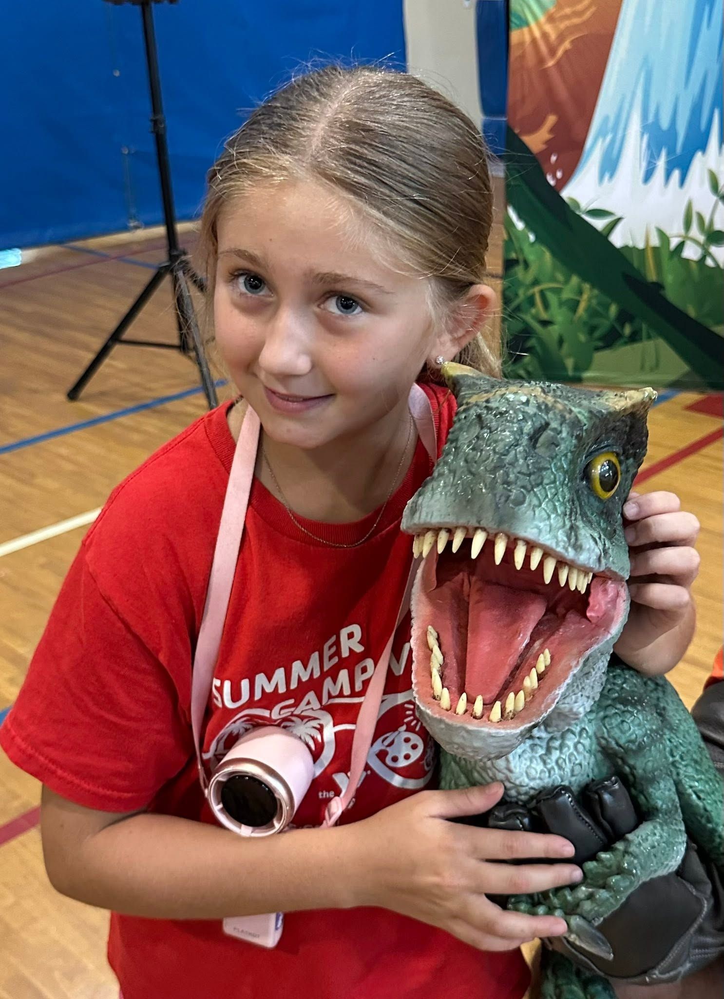 A girl hugs a lifelike baby T. rex