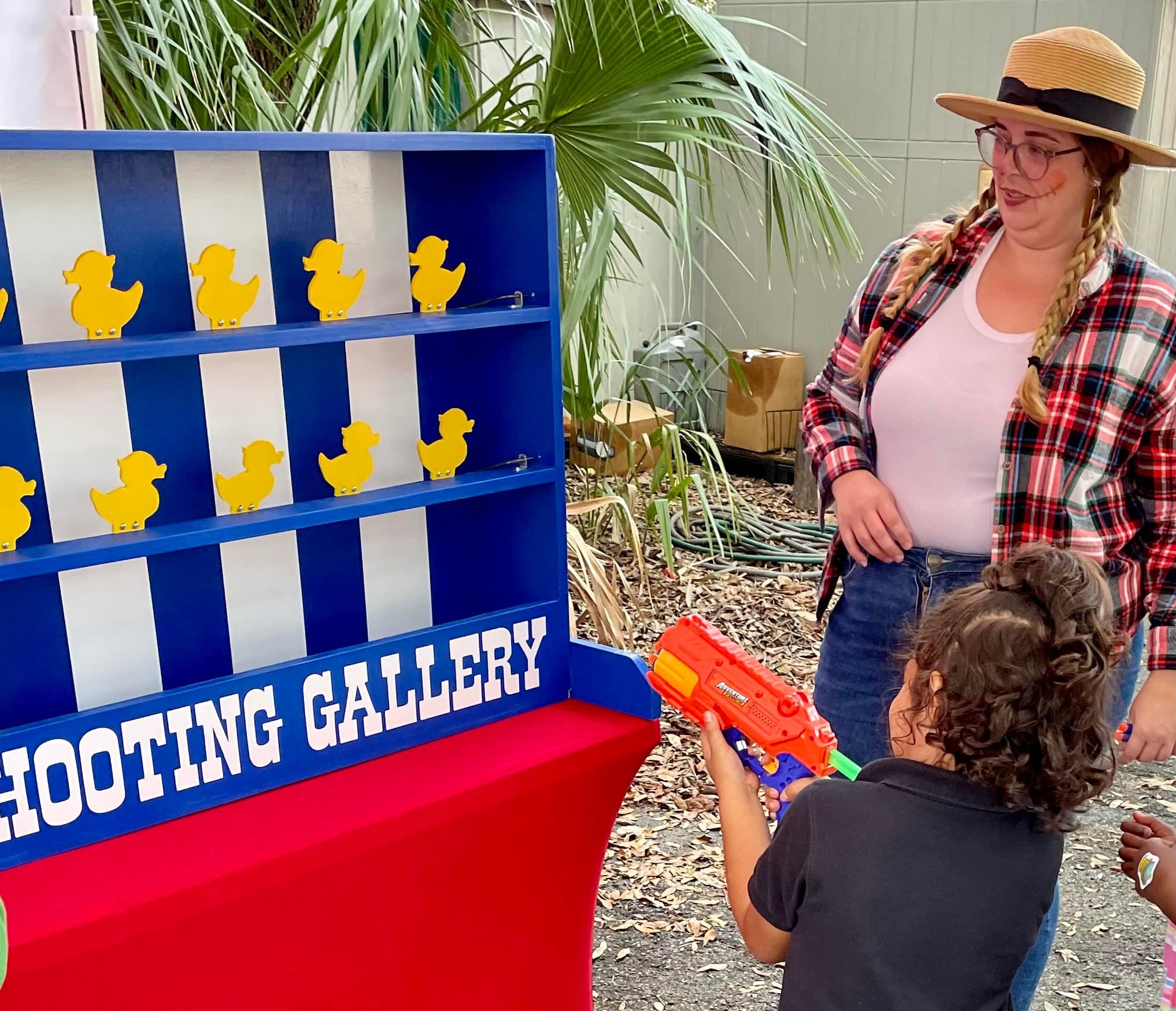 kids playing the duck shooting gallery carnival game at a birthday