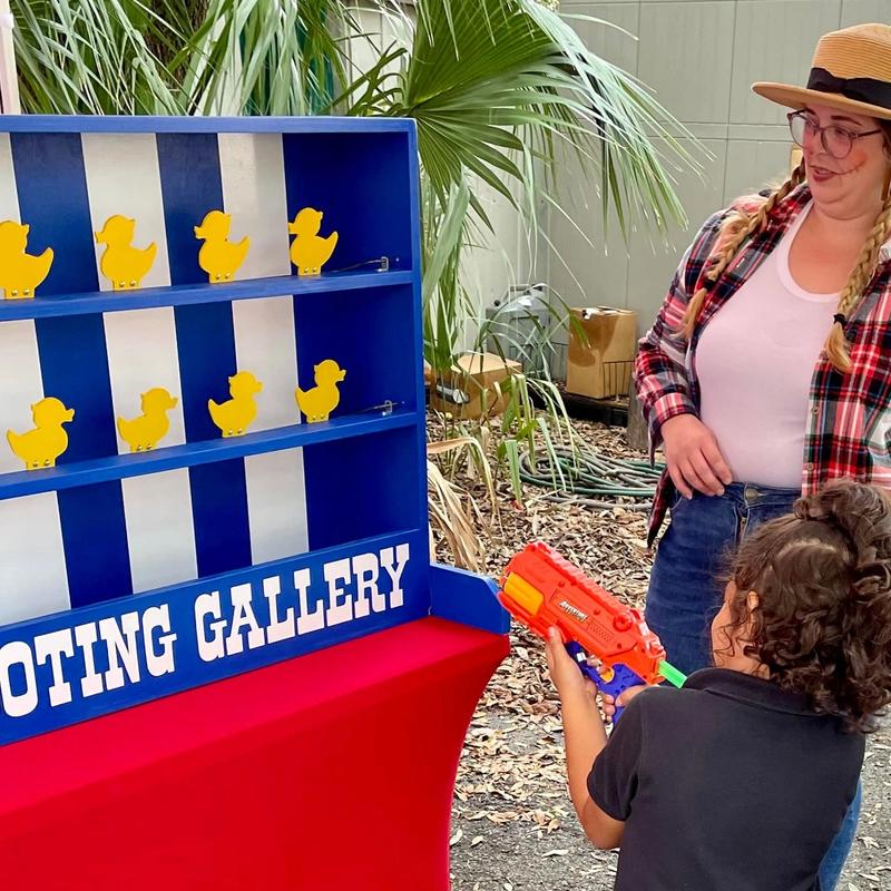 kids playing the duck shooting gallery carnival game at a birthday