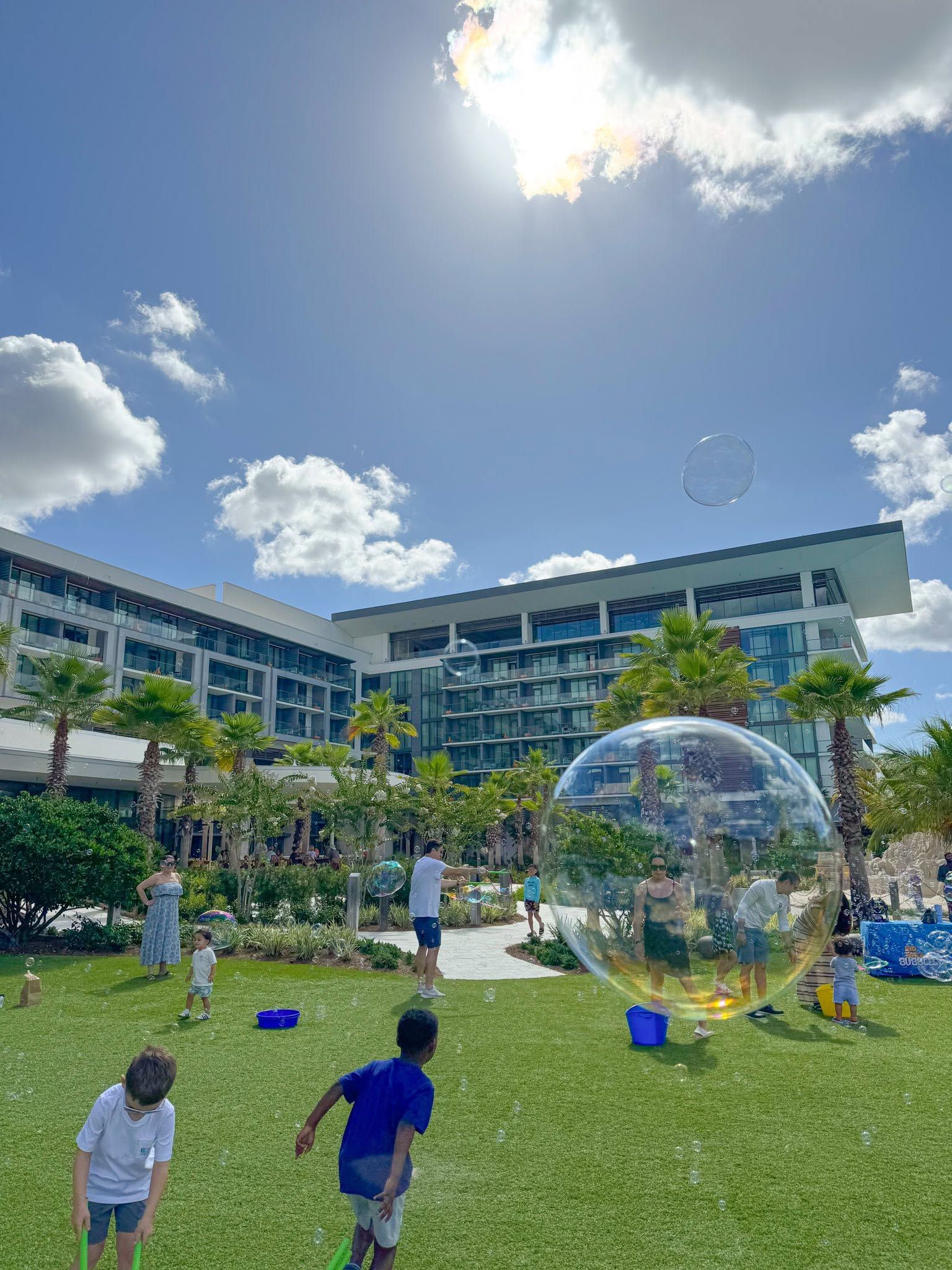 a child standing inside a giant bubble on a lawn