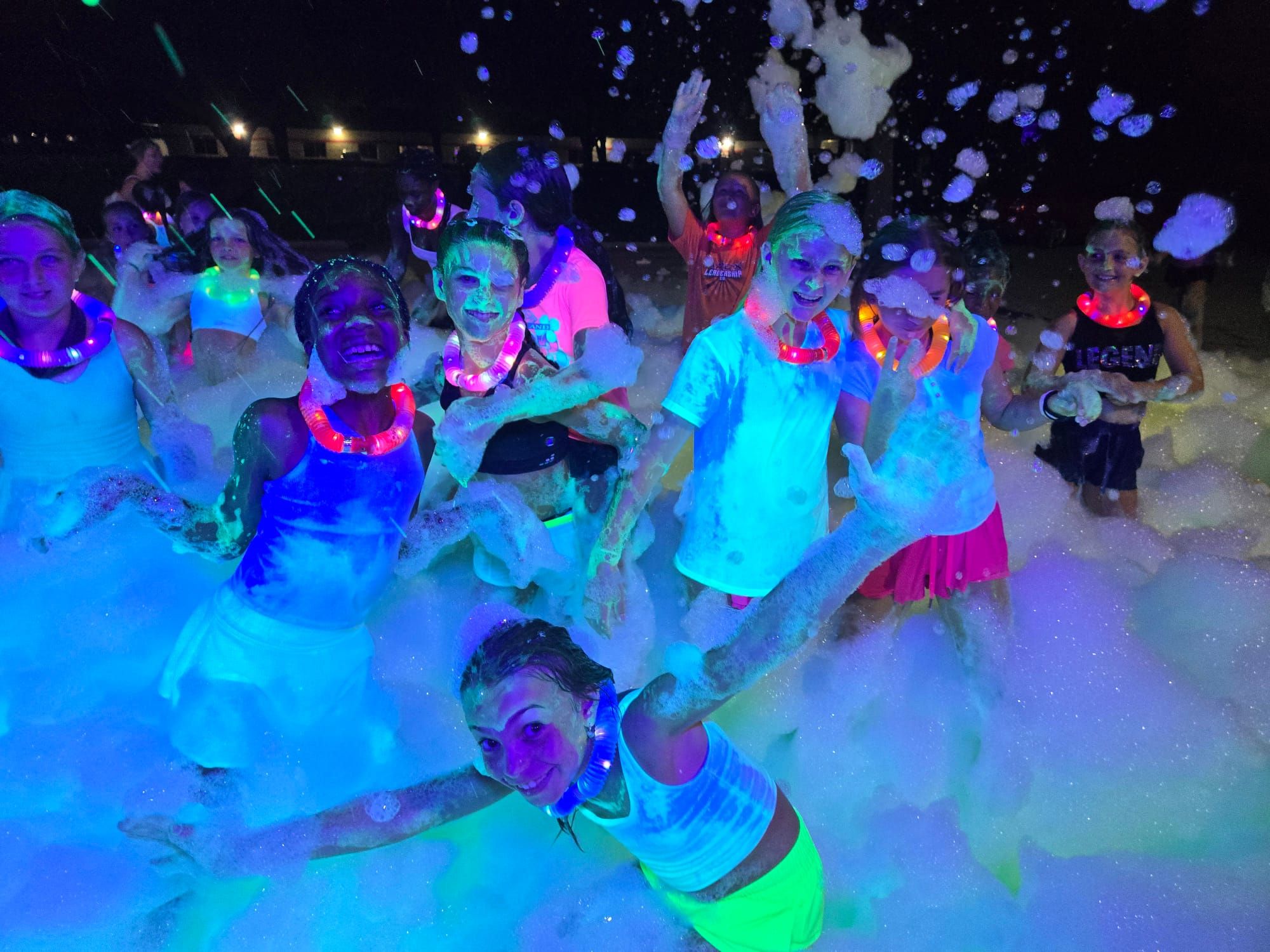 Teens playing in foam at a glow in the dark foam party in Marietta