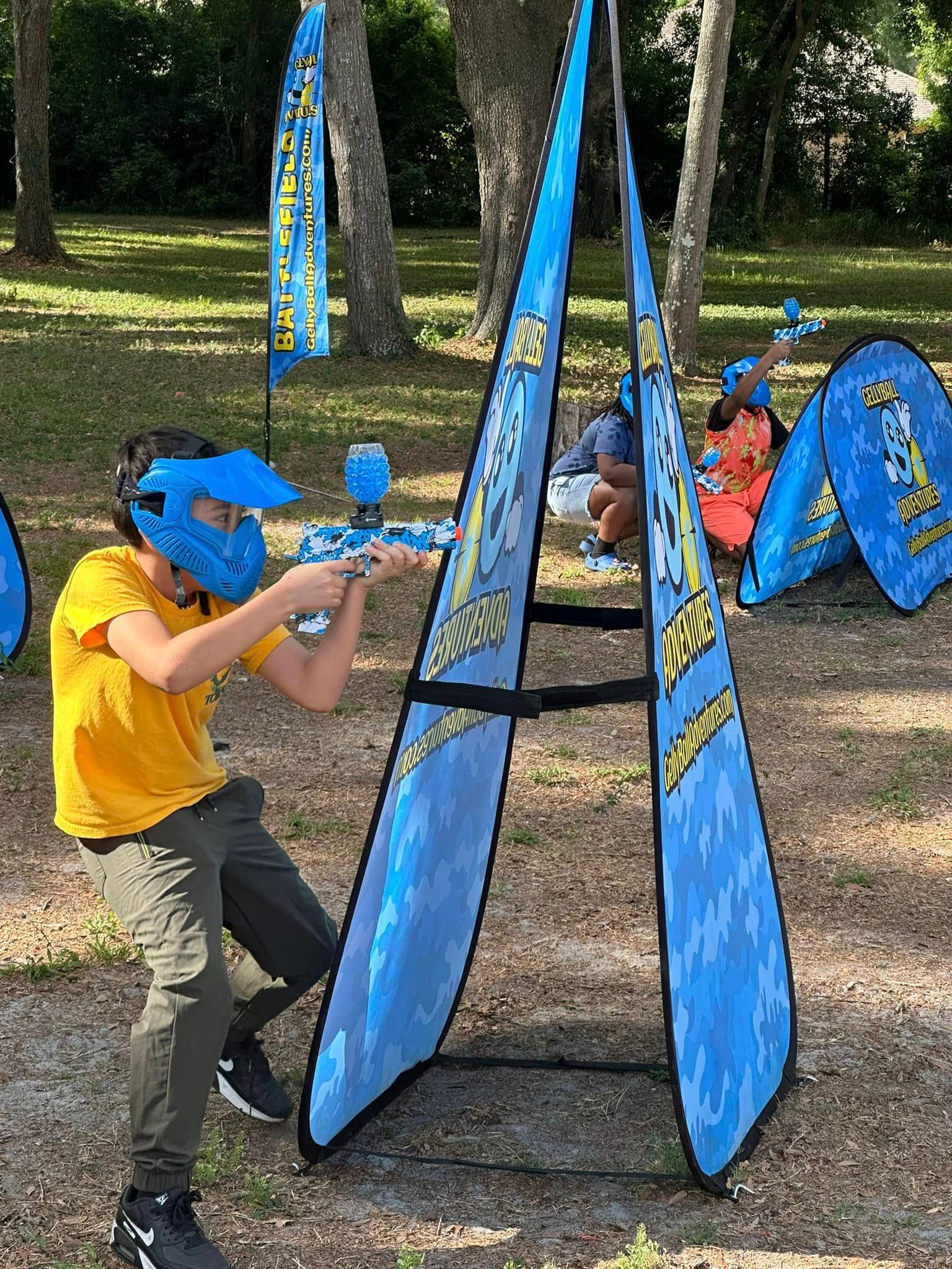 A boy in a blue mask aims around a pop-up bunker