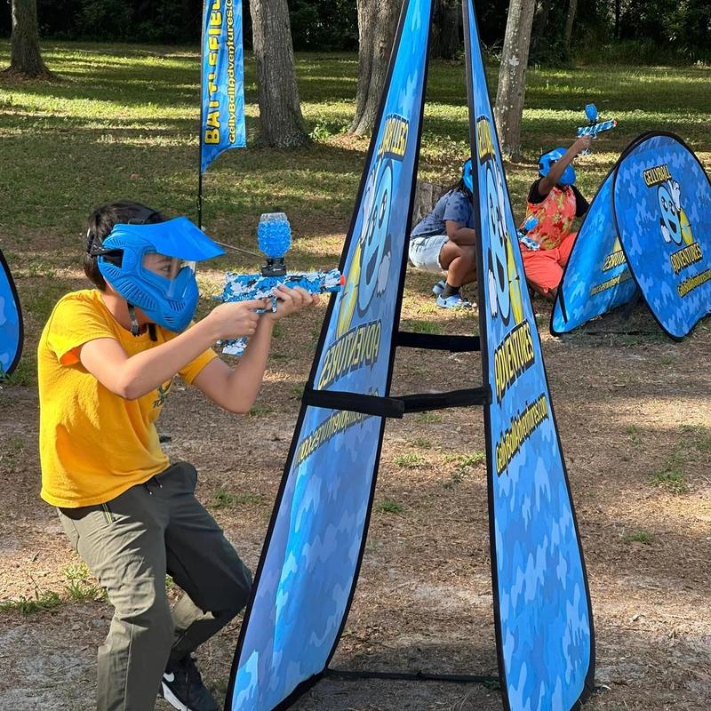 A boy in a blue mask aims around a pop-up bunker