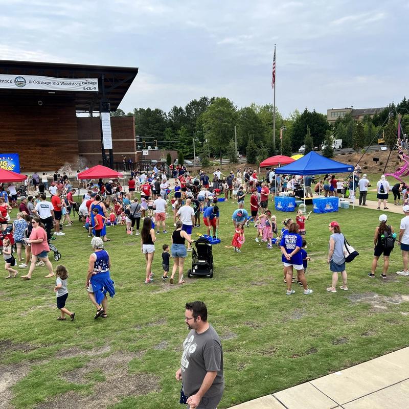 a large crowd of kids and parents at a community carnival event.