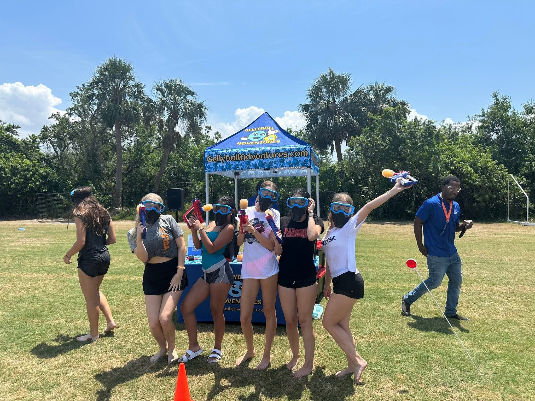 Teens in goggles on a sports field in front of the Gellyball Adventures tent