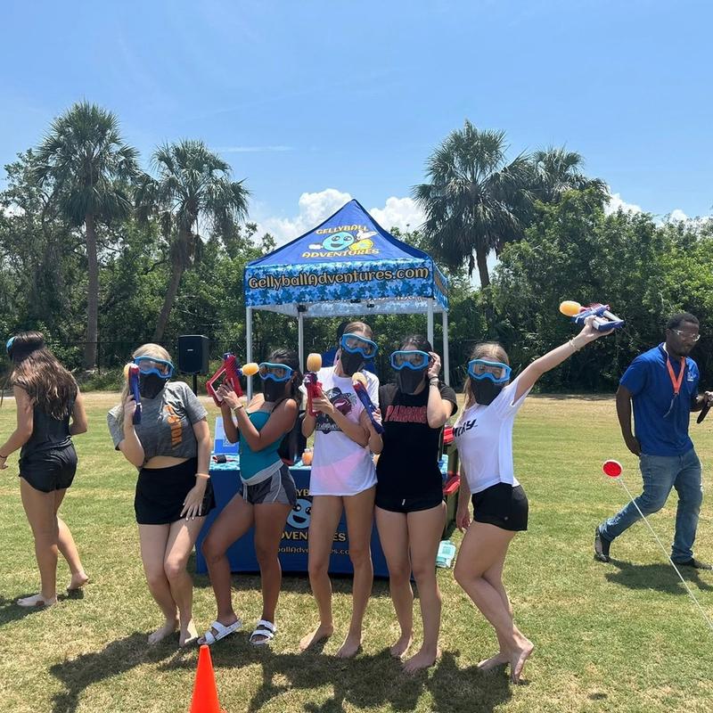 Teens in goggles on a sports field in front of the Gellyball Adventures tent